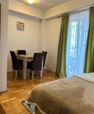 a room with a table and chairs and a bed at Urban studio Blok 9 in Podgorica