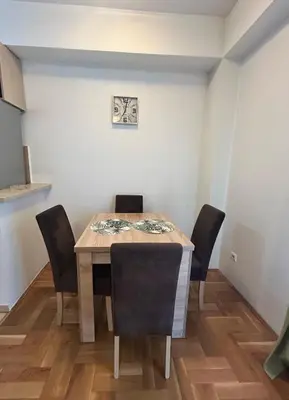a dining room table and chairs in a room at Urban studio Blok 9 in Podgorica