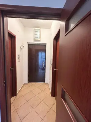 a hallway with a door and a tile floor at Urban studio Blok 9 in Podgorica