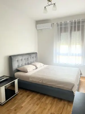 a bedroom with a large bed with a window at Urban studio City kvart in Podgorica