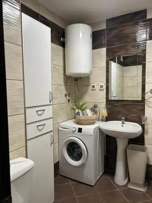 a bathroom with a washing machine and a sink at Urban studio City kvart in Podgorica