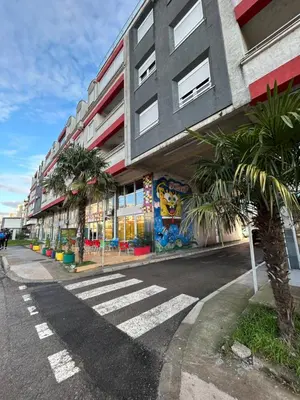 an empty street with a building and palm trees at Urban studio City kvart in Podgorica