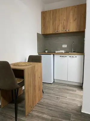 a small kitchen with a table and a refrigerator at Vila Seawolf Apartments in Sutomore
