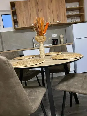 a table with chairs and a vase with flowers on it at Vila Seawolf Apartments in Sutomore