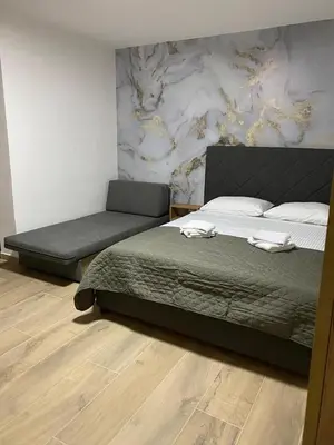 a bedroom with a large bed and a couch at Vila Seawolf Apartments in Sutomore
