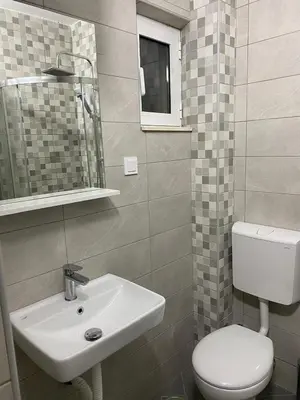 a bathroom with a sink and a toilet and a mirror at Vila Seawolf Apartments in Sutomore