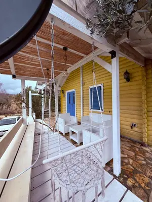 a porch with white chairs and a porch swing at La Belle Saison