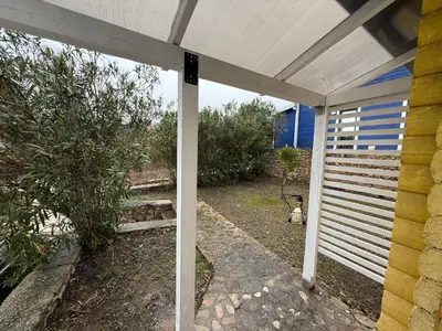 a white pergola on the side of a house at La Belle Saison