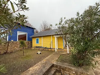 a yellow and blue house with a yard at La Belle Saison