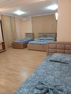 three beds in a room with wooden floors at Grandino Space room&apart Ulqin in Ulcinj