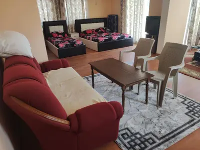 a living room with a red couch and a table and chairs at Grandino Space room&apart Ulqin in Ulcinj