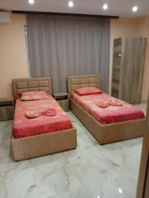 two beds in a room with red covers on them at Grandino Space room&apart Ulqin in Ulcinj