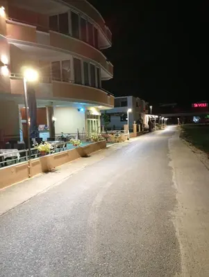 an empty street in front of a building at night at Grandino Space room&apart Ulqin in Ulcinj