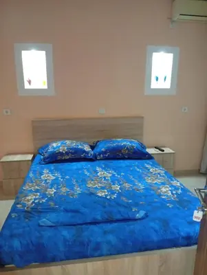 a bedroom with a blue bed with two pillows at Grandino Space room&apart Ulqin in Ulcinj