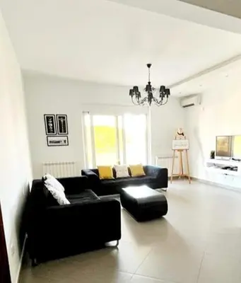 a living room with two black couches and a chandelier at Le Domaine paradise