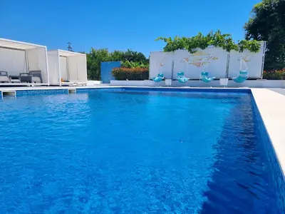 a swimming pool with blue water in a backyard at Le Domaine paradise