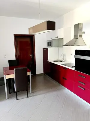 a kitchen with a red counter and a table and a kitchen at Le Domaine paradise