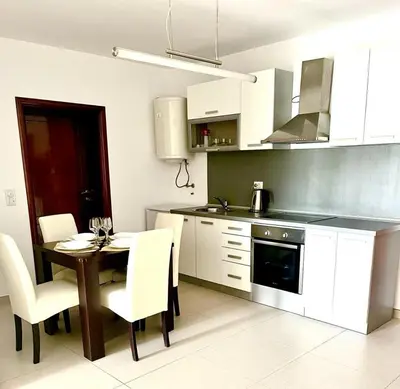 a kitchen with a table and white cabinets at Le Domaine paradise