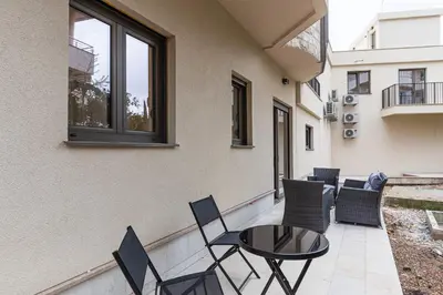 a patio with chairs and a table on a balcony at Green Oasis Bečići in Boreti