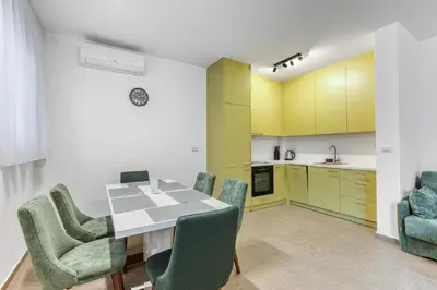 a kitchen and dining room with a table and chairs at Green Oasis Bečići in Boreti