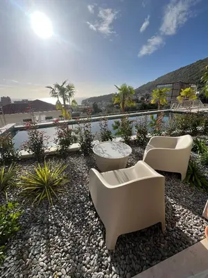 a patio with two couches and a table and chairs at OLIVA RESIDENCe in Petrovac na Moru