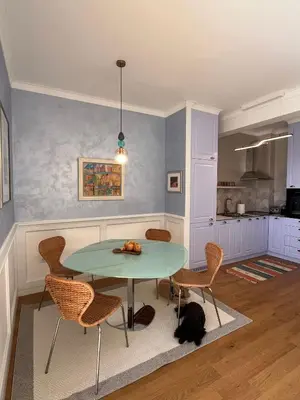 a dining room with a table and chairs and a dog at OLIVA RESIDENCe in Petrovac na Moru