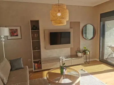 a living room with a table and a tv at OLIVA RESIDENCe in Petrovac na Moru