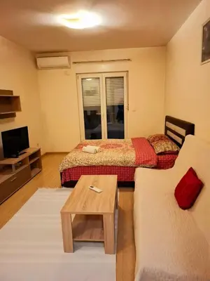 a living room with two beds and a couch at City kvart apartman in Podgorica