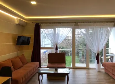 a living room with a couch and a large window at Oaza mira Sutomore in Bar