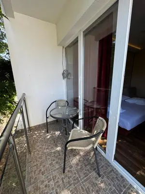 a balcony with a table and chairs and a bed at Oaza mira Sutomore in Bar
