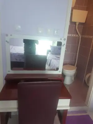a small bathroom with a bed and a toilet at Apartmani Micunovic in Sutomore