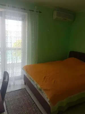 a green bedroom with a bed and a window at Apartmani Micunovic in Sutomore