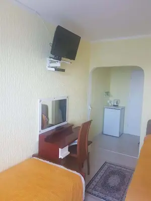 a hotel room with a desk and a tv on the wall at Apartmani Micunovic in Sutomore