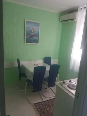 a dining room with a table and blue chairs at Apartmani Micunovic in Sutomore