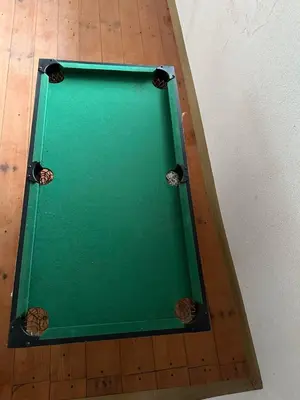 a green pool table sitting on top of a wooden floor at Etno Village Revival