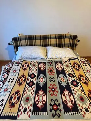 a bed with a colorful comforter on it at Etno Village Revival
