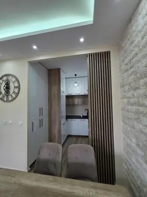 a dining room with two chairs and a kitchen at S&M Stan in Ulcinj