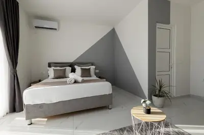 a bedroom with a large bed and a table at NOVA Apartments in Ulcinj
