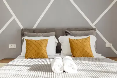 a bed with two pillows and two towels on it at NOVA Apartments in Ulcinj