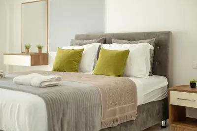 a bedroom with a large bed with white and green pillows at NOVA Apartments in Ulcinj