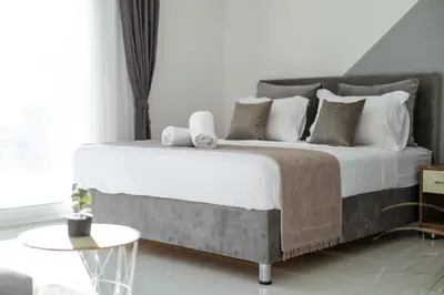 a bedroom with a large bed with white sheets and pillows at NOVA Apartments in Ulcinj