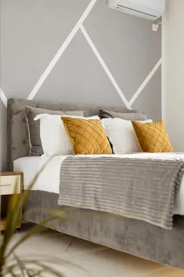 a bedroom with a bed with white and gold pillows at NOVA Apartments in Ulcinj