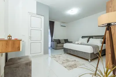 a white bedroom with a bed and a couch at NOVA Apartments in Ulcinj