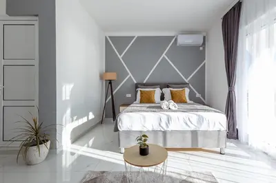 a bedroom with a bed with a gray wall at NOVA Apartments in Ulcinj