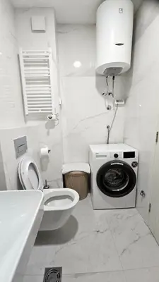 a bathroom with a toilet and a washing machine at CL Home Lux in Podgorica