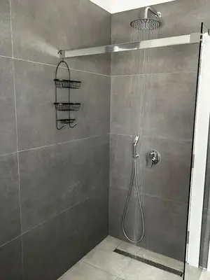 a bathroom with a shower with a glass door at Apartment Sunset - Private Pool & Sea View in Bar