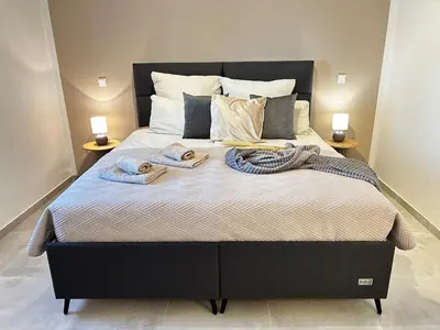 a large bed with two towels on top of it at Apartment Sunset - Private Pool & Sea View in Bar