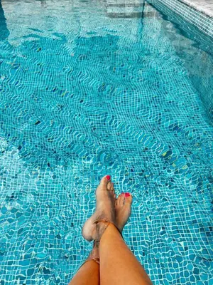 a person laying on the side of a swimming pool at Apartment Sunset - Private Pool & Sea View in Bar
