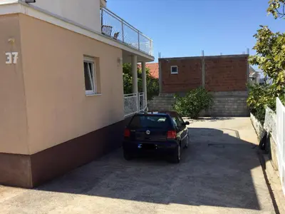 a car parked in a parking lot next to a building at Apartment Dorada in Dobra Voda