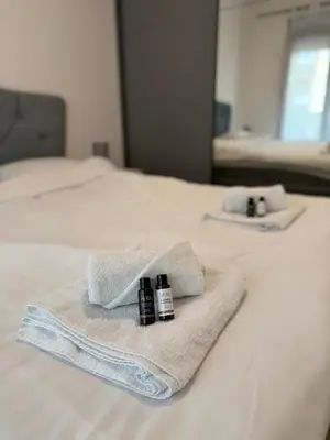 two towels and two bottles on a bed at Montenegro Platinum Suite - New City in Podgorica